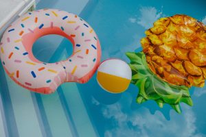 A picture of a inner tube shaped like a donut , beach ball, and a water air bed that looks like a pineapple. These are all examples of what could be blown up with a portable air pump.